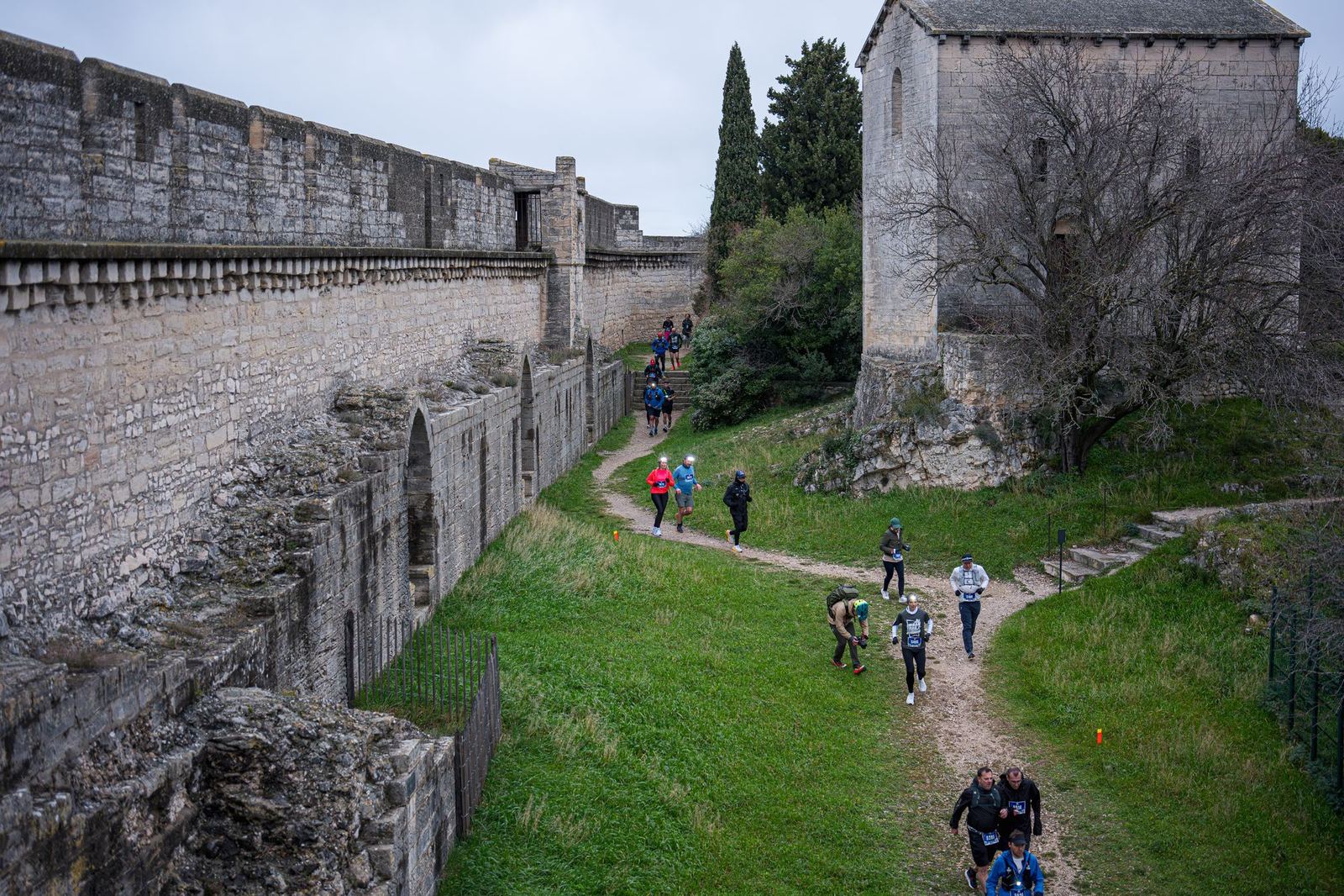 File de coureurs au pied des murs de pierre