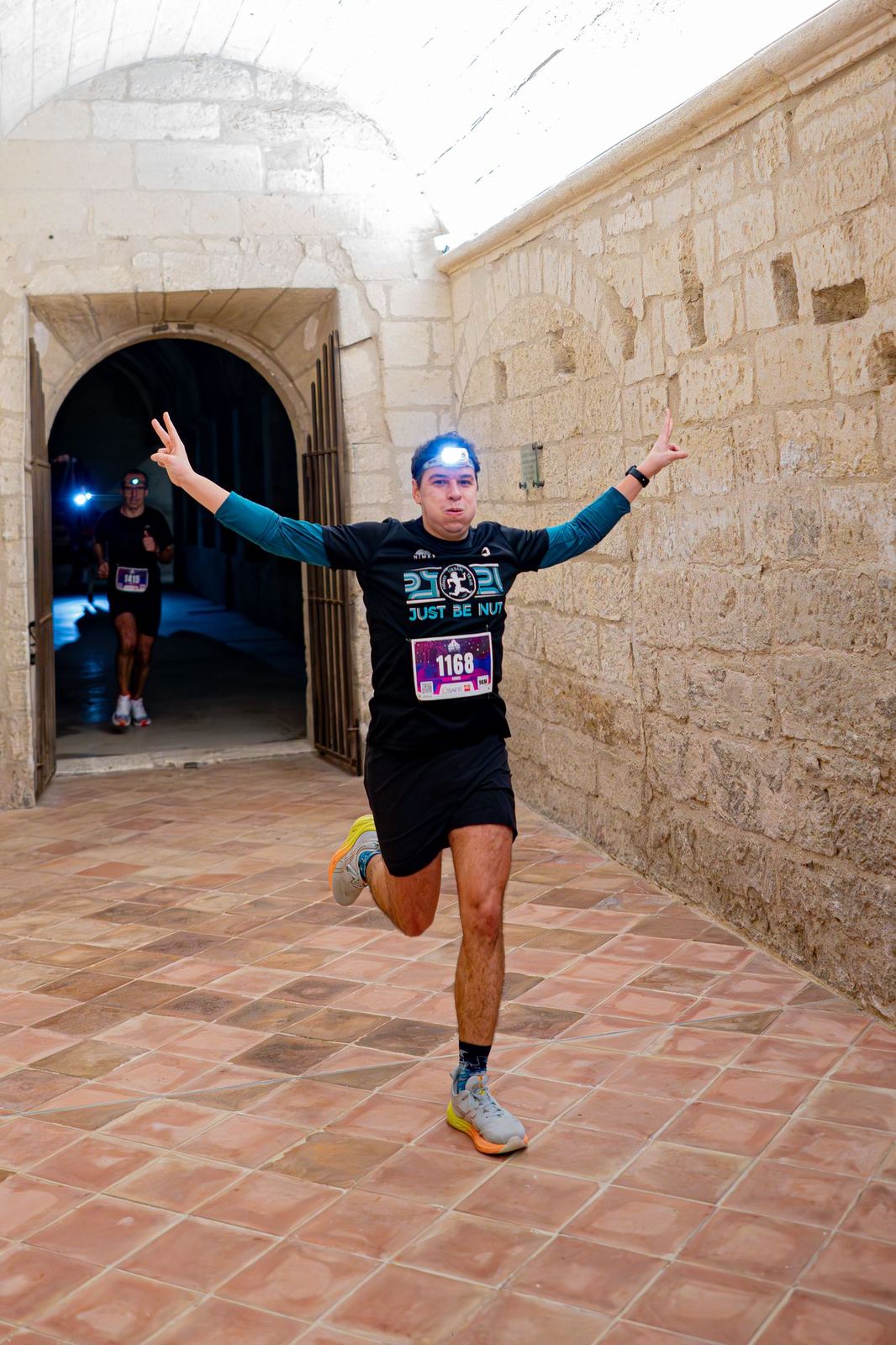 Coureur bras levés dans un couloir voûté