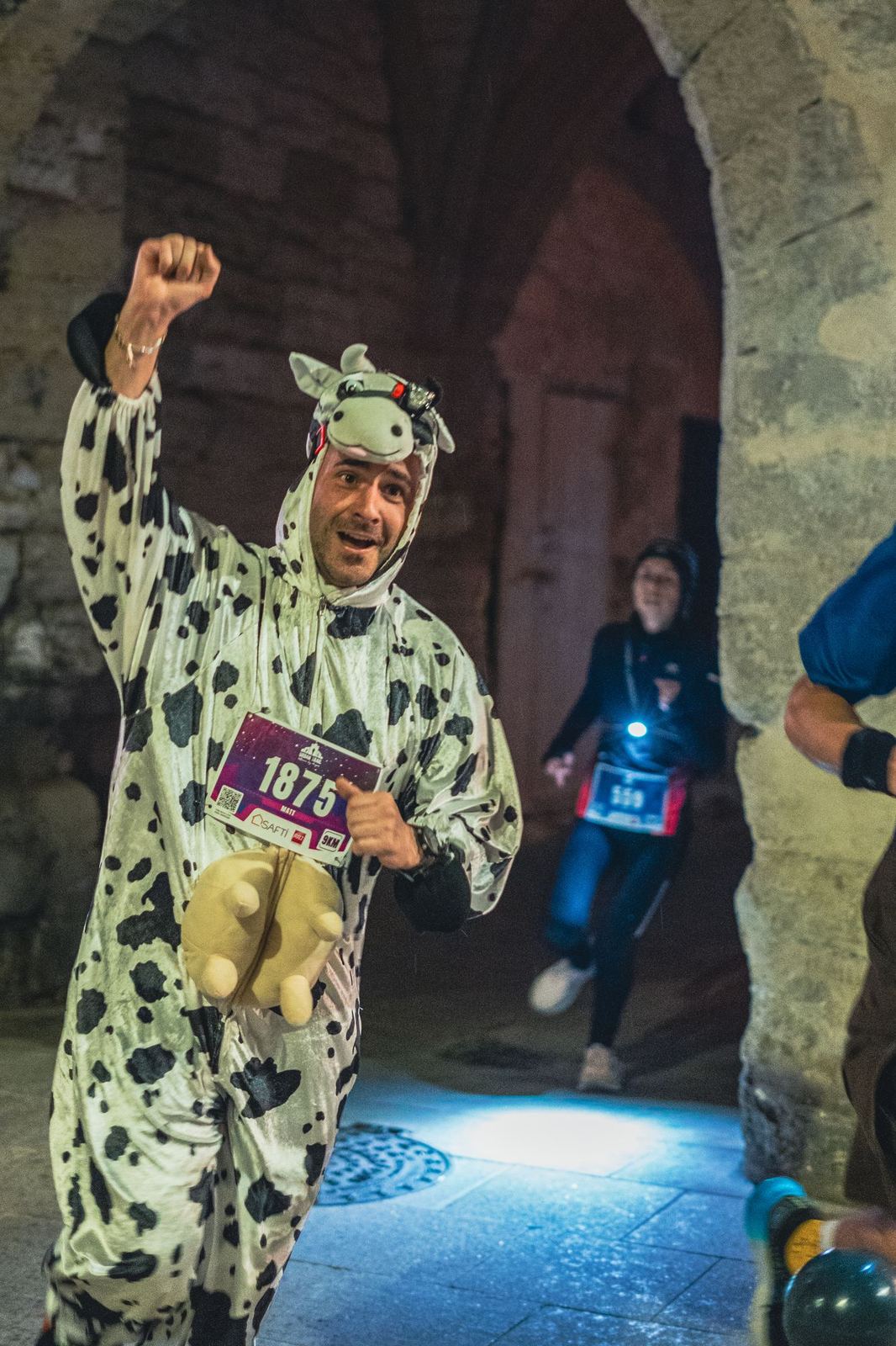 Coureur déguisé en vache, poing levé