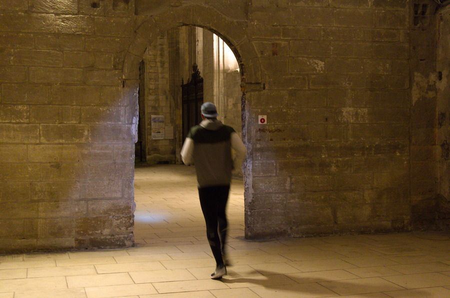 Coureurs passant sous une arche de pierre