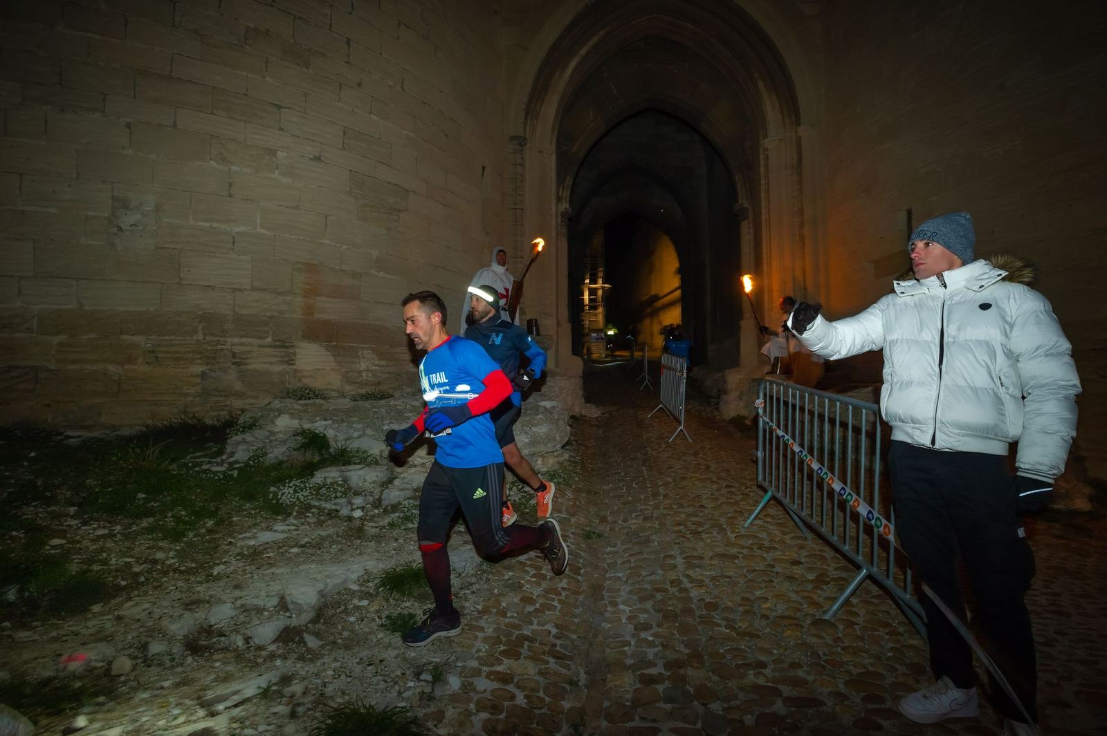 Bénévole encourageant un coureur sous les voûtes