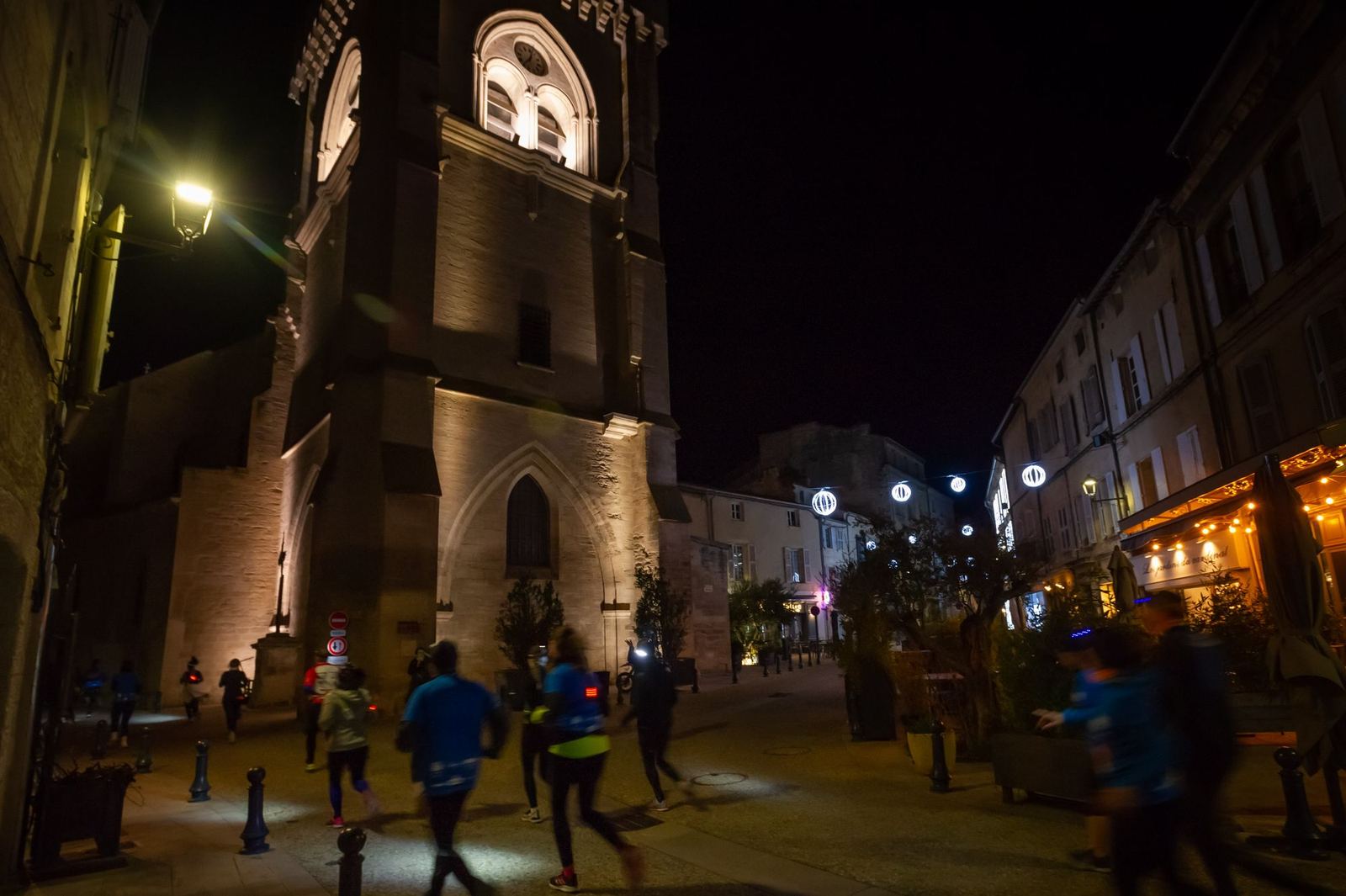 Coureurs dans une rue sous le clocher