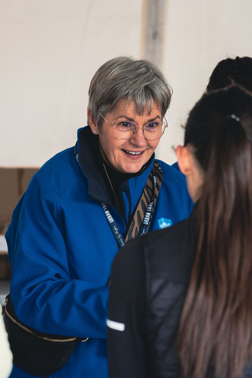 Bénévole souriante accueillant une coureuse