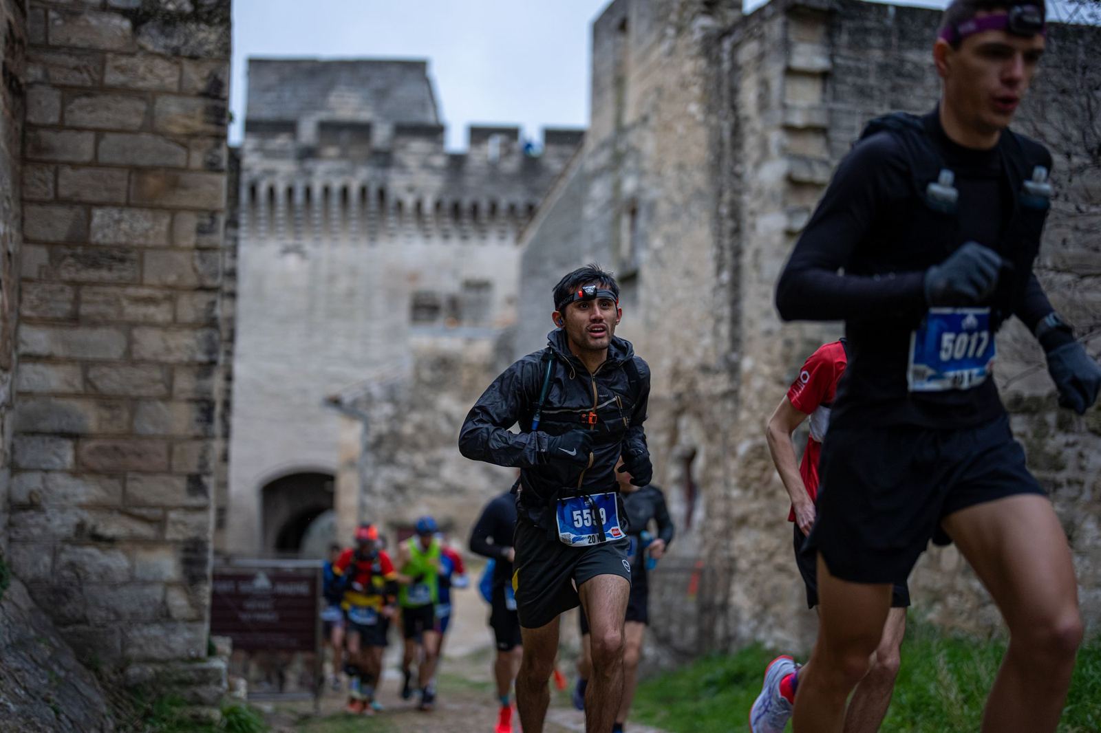 Coureurs sortant d'une porte de pierre